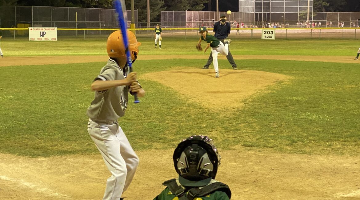 A photo of a pitcher throwing to a batter from a High Park Little League majors division game in August 2021