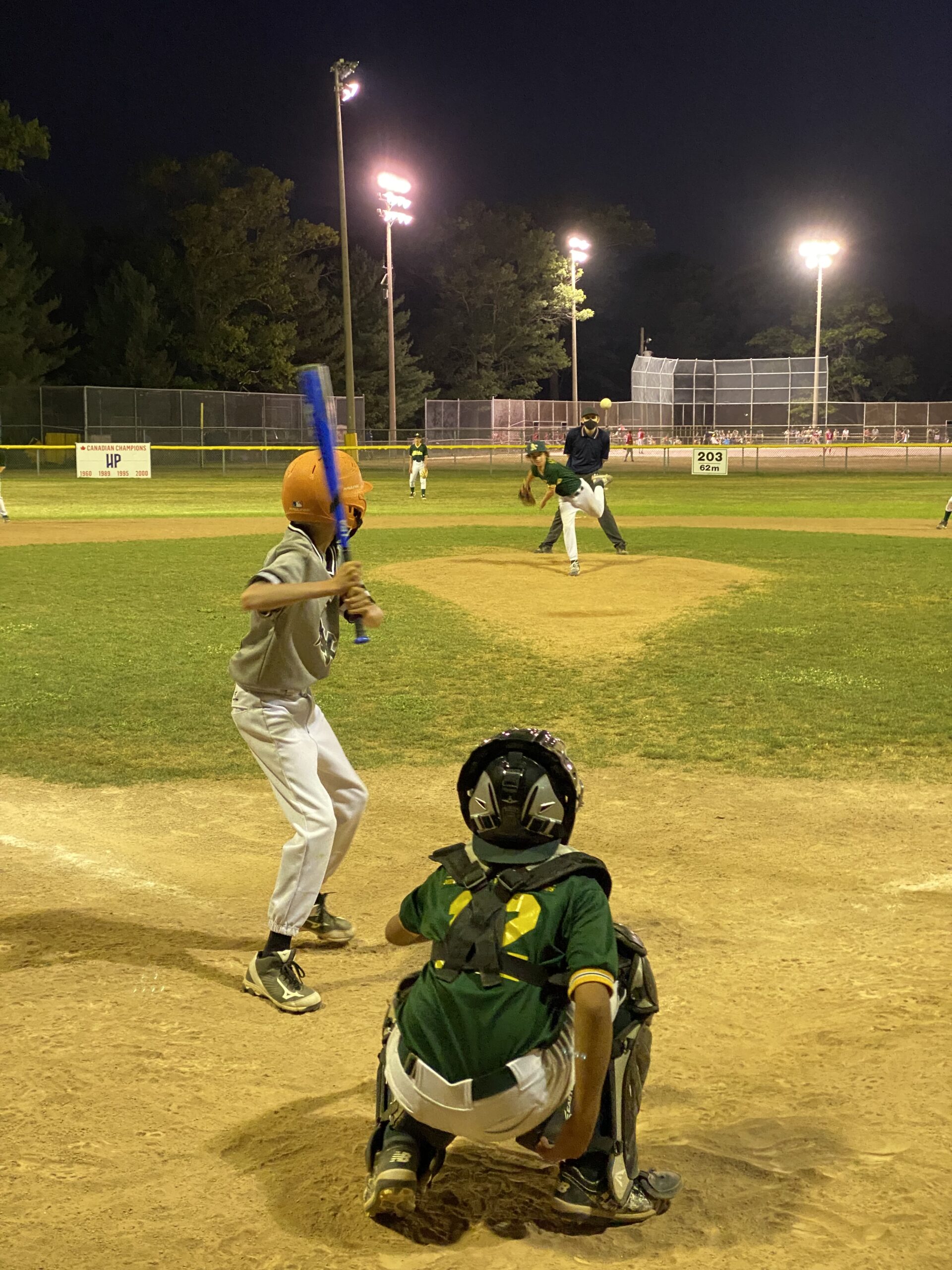 A photo of a pitcher throwing to a batter from a High Park Little League majors division game in August 2021